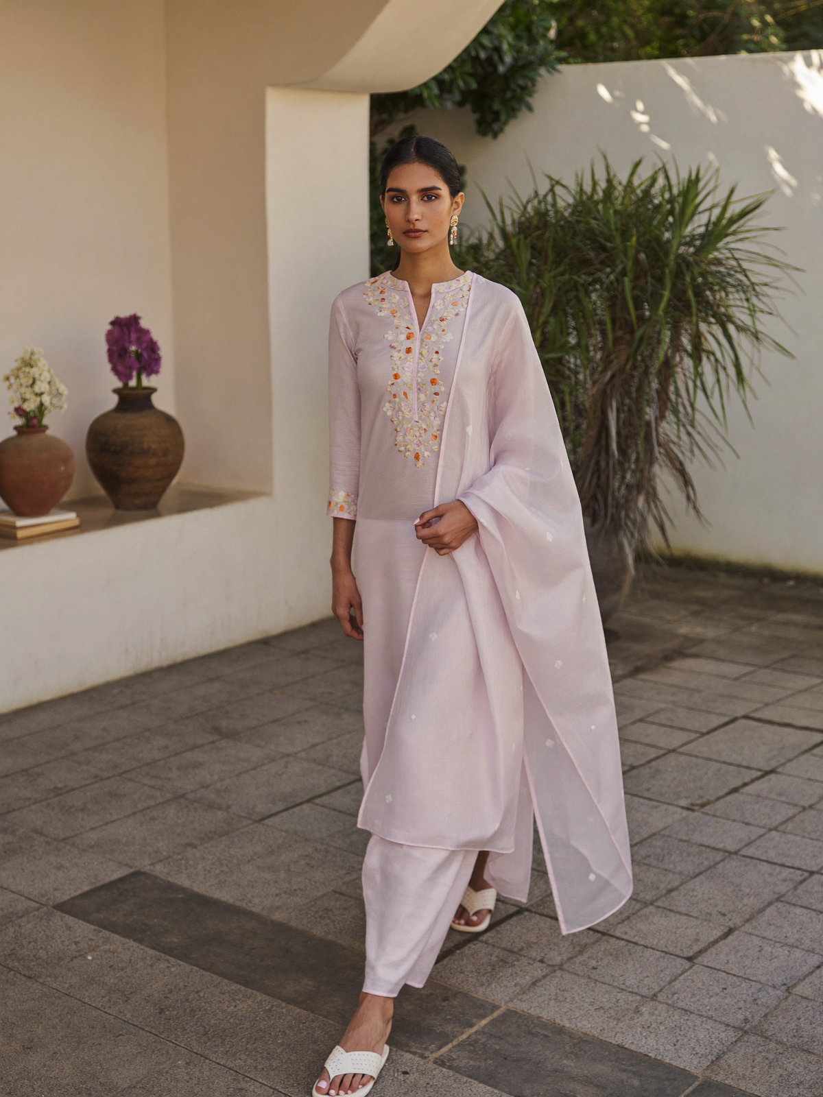 Woman in a pastel cotton kurti in a sunlit courtyard